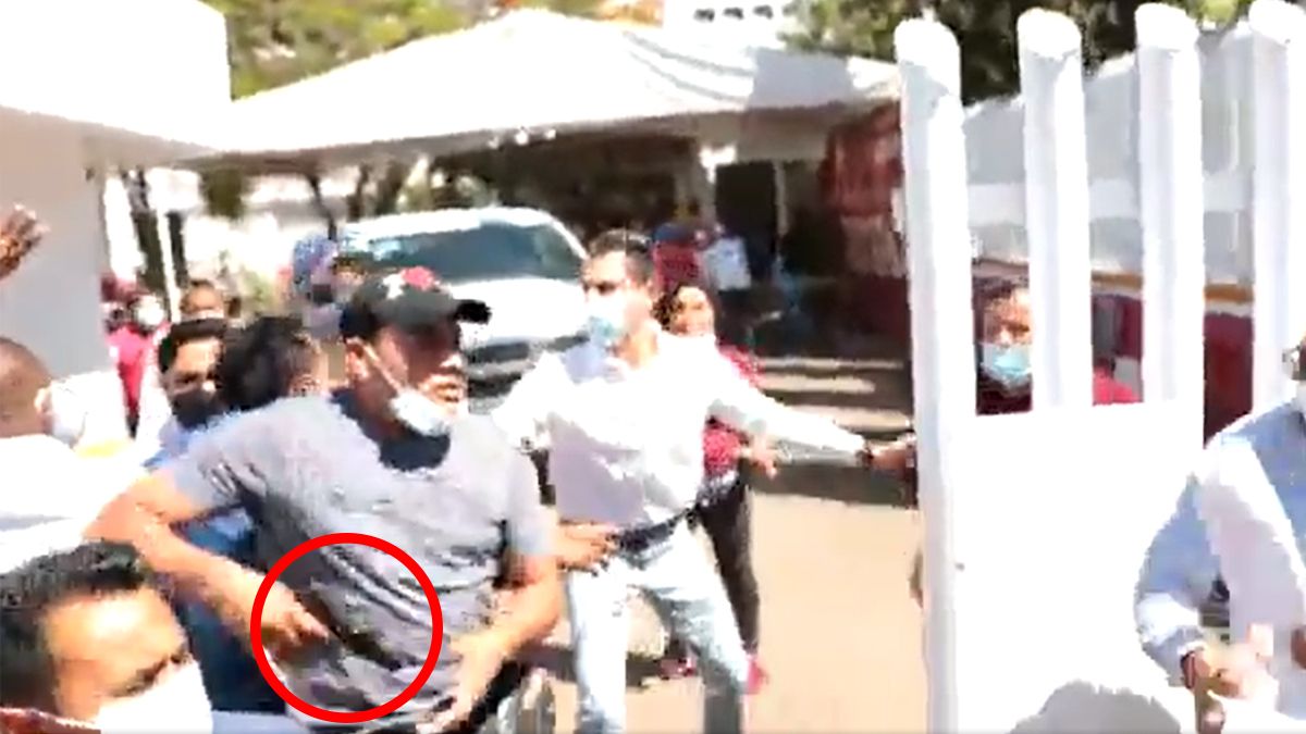 Escolta de delegada del Bienestar desenfunda su arma durante protesta